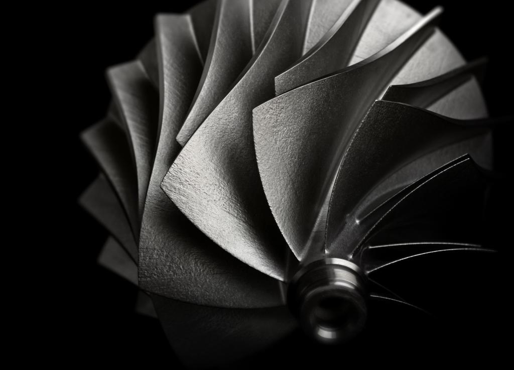 Close up photo of components for jet engines, fanned out in a spiral from the center